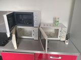 two microwaves that are sitting on top of a counter