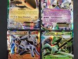 Quatre cartes Pokémon différentes sont représentées sur une surface noire.