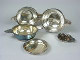 four pieces of silverware on a white surface with spoons