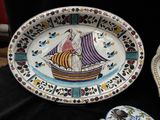 a plate with a boat painted on it on a table