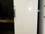 a white refrigerator sitting in a kitchen next to a black wall