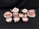 un assortiment d'assiettes et de tasses roses et blanches posées sur un fond noir