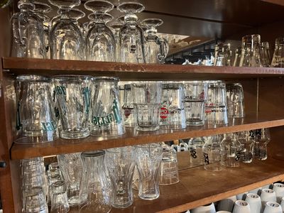 de nombreux verres et tasses sur une étagère dans un magasin