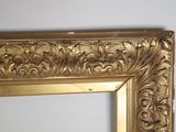 a picture of a gold framed mirror hanging on a wall