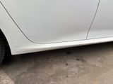 a white car parked in a parking lot next to a building