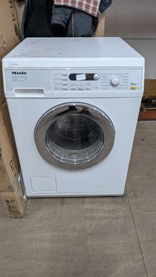 une machine à laver posée sur le sol