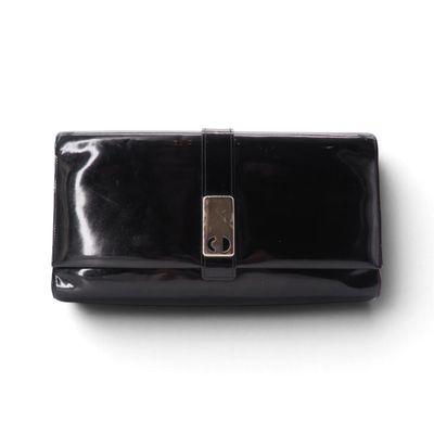 pochette en cuir noir sur fond blanc, avec une image découpée représentant le fermoir