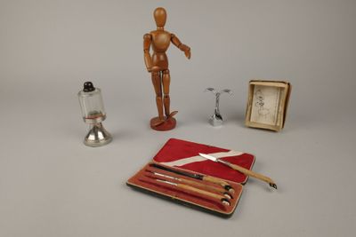 un mannequin en bois et d'autres objets posés sur une table