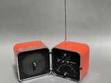 une radio orange et une radio noire posées l'une à côté de l'autre sur une table