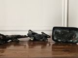three figurines sitting on a wooden table next to each other