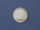 a close up of a silver coin on a blue cloth