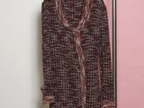 un manteau suspendu à un porte-vêtements devant un mur rose