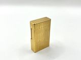 an image of a gold lighter sitting on top of a white surface