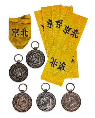 four medals and a gold ribbon with chinese characters on them