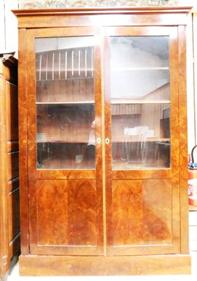 un grand meuble en bois avec des portes en verre dans une pièce