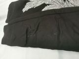 a black shirt with a white design on it on a bed