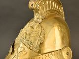 gold helmet of a roman soldier on a stand with a black background