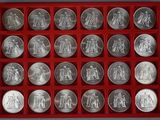 an assortment of silver coins in a red tray on a table