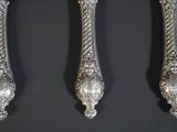 three silver spoons and a fork on a black surface