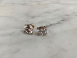 a pair of diamond stud earrings on a marble surface