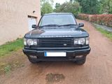 une Land Rover noire garée sur le bord d'un chemin de terre