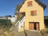 the house is yellow and has brown shutters on the windows