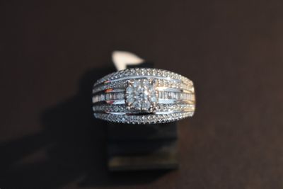 une image d'une bague en diamant sur une surface noire