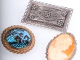 three pieces of brooches are sitting on a white surface