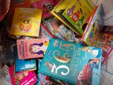 a pile of children ' s books on a bed