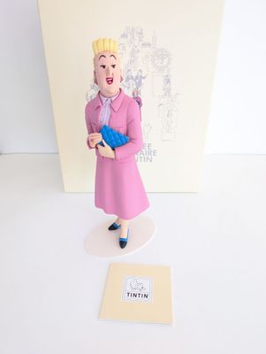 une figurine représentant une femme en robe rose tenant un gant bleu