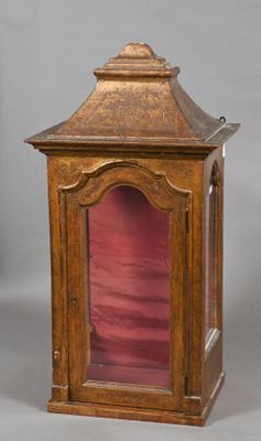 une vieille horloge en bois surmontée d'un couvercle en verre rouge