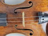 a close up of a violin that is on a table