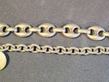 two silver bracelets on a table with a tag attached to them
