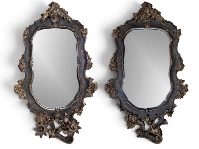 On voit deux miroirs aux motifs ouvragés sur fond blanc