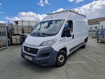une camionnette blanche garée sur un parking, avec un ciel bleu en arrière-plan