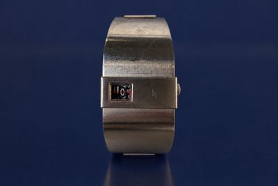 a close up of a wrist watch on a blue surface