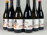 six bouteilles de vin sont alignées sur une surface blanche