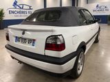 the back of a white car with a black top in a garage