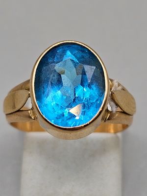 an image of a gold ring with a blue topaz stone