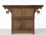 une vieille armoire en bois ornée de sculptures sur le dessus