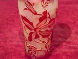 un vase en verre posé sur une table, sur lequel est collée une étiquette