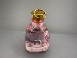 a bottle of perfume with a gold lid on a table