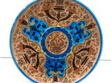 a blue and brown plate with a design on it