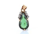 a green tourmaline and diamond pendant on a white background