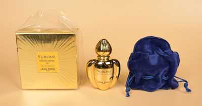 un gros plan sur un flacon de parfum à côté d'un sac bleu