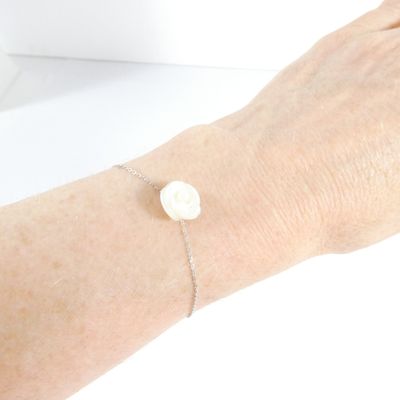 someone is wearing a bracelet that has a white button on it