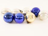 several blue and silver christmas ornaments on a white surface
