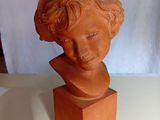une sculpture en argile représentant la tête d'une femme, posée sur une table