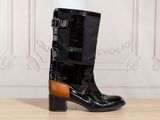 black and brown leather boots with buckles on a wooden floor