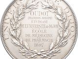 an image of a silver coin with a wreath of leaves on it